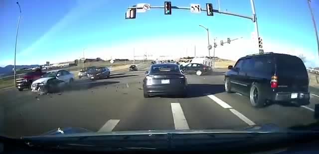 Dashcam view of a car crash at a red light.