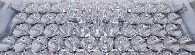 A wall of silver lamp reflectors in a large array.