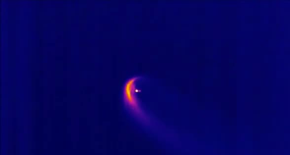 An infrared view of a rocket stage glowing during reentry.
