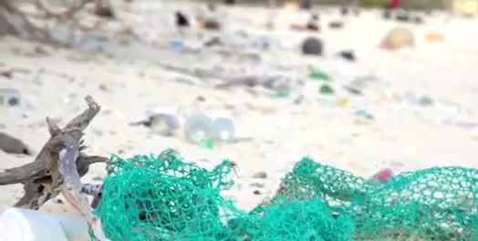 Plastic nets and bottles scattered on a beach.