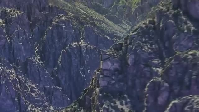 A close aerial view of a steep rocky mountain ridge.