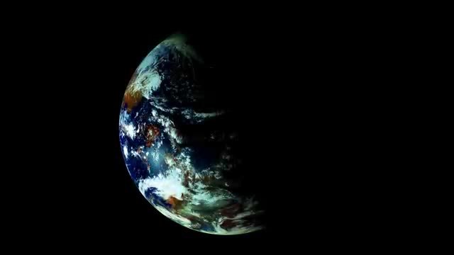A partly lit Earth against black space, with clouds and the day-night line.