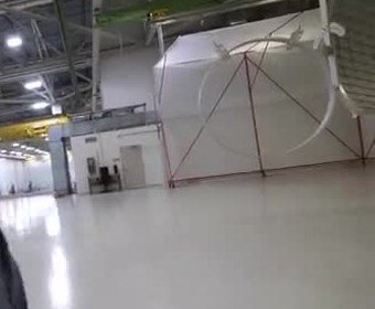 Large white rocket-tank ring standing in a high-bay factory