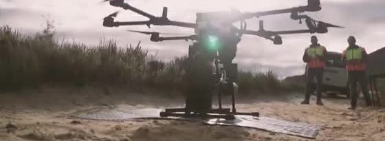 A multi-rotor tree-planting drone on the ground, with seed canisters under the frame.