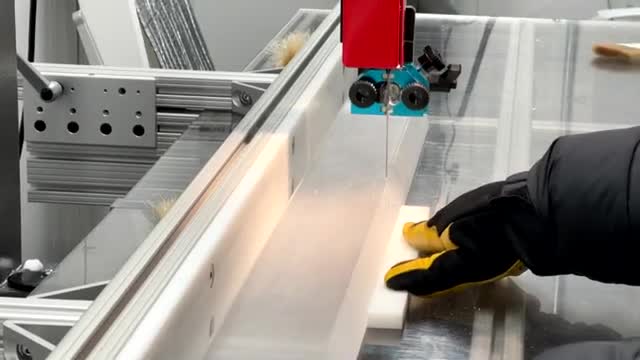 A gloved hand guiding an ice core under a saw