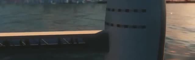A rocket booster beside a launch structure over water