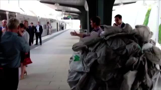 A heap of stuffed rubbish bags on a train platform