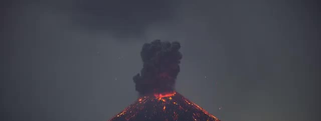 Anak Krakatau glowing at night under a dark plume.